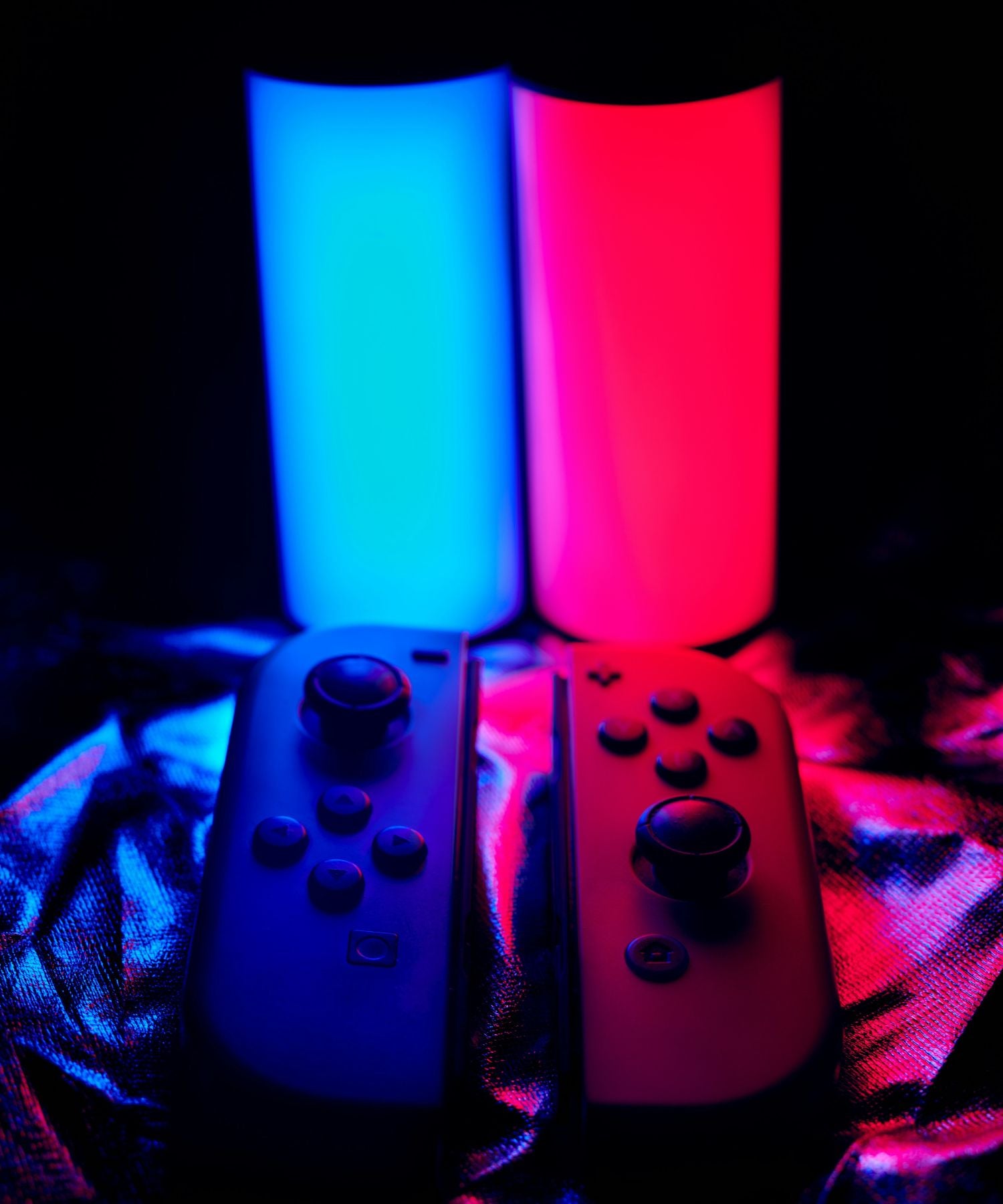 Joy-Con Nintendo Switch illuminés en rouge et bleu par deux bâtons lumineux